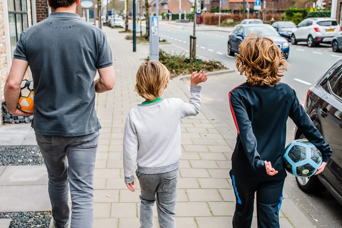 Vader met twee zoontje lopen over straat tijdens een fotoreportage in Oosterhout