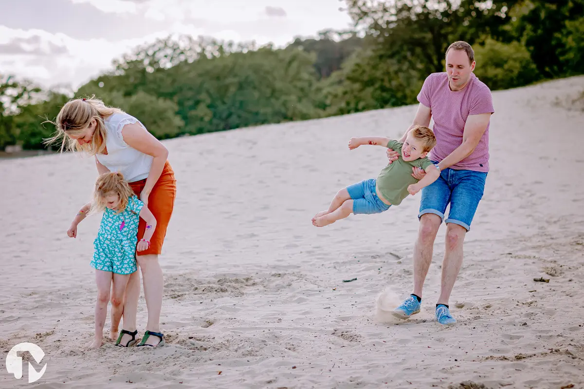 Jong gezin spelen samen in de Drunense Duinen tijdens hun fotosessie.