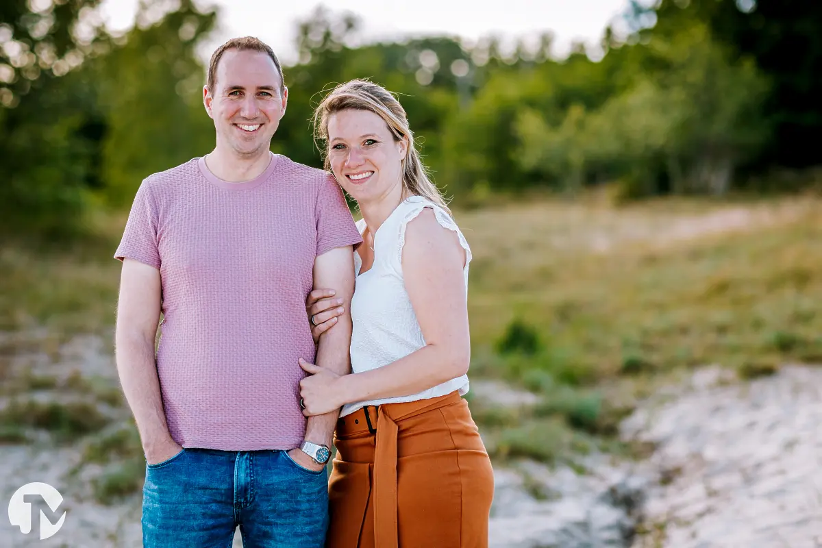 Papa en mama poseren even voor de foto op een buiten locatie.