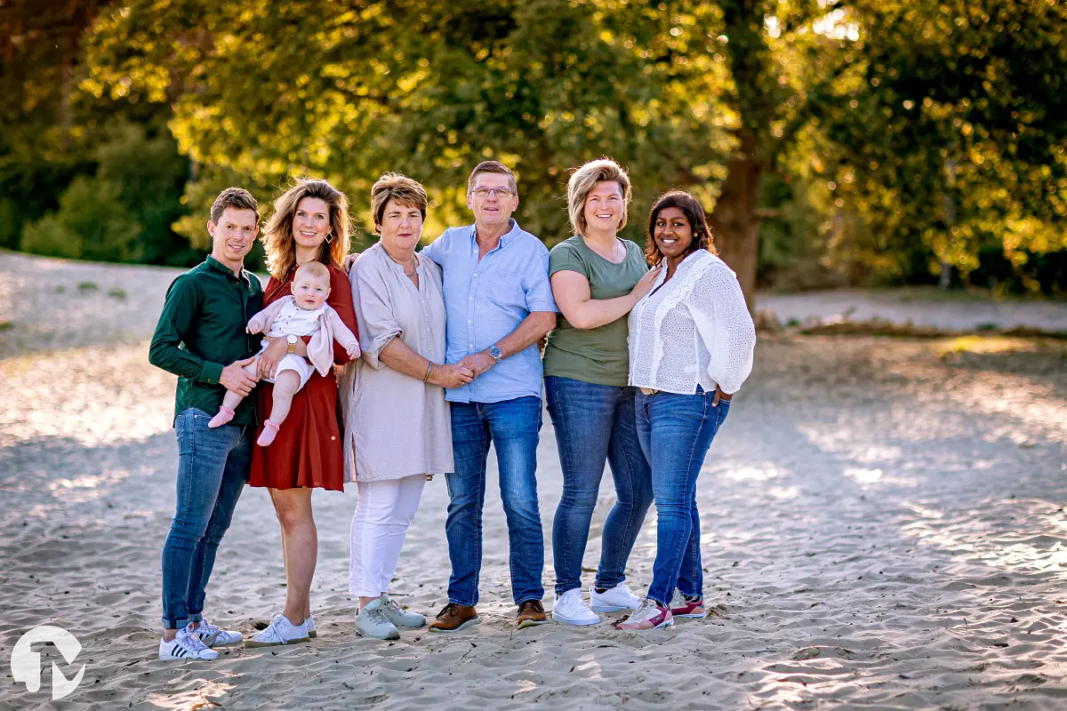 Familie poseert voor de foto in de Roestelberg bij een avondzon.