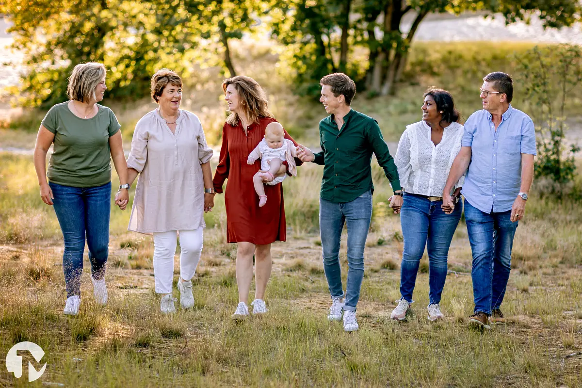Familie loopt hand in hand tijdens een fotoreportage in de Loonse Duinen.