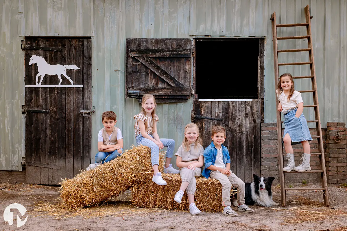 Portretfoto met kinderen en een hond op een boerderij.