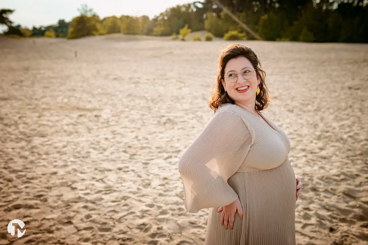 Zwangere vrouw poseert tijdens een zwangerschaps fotoshoot in de natuur.