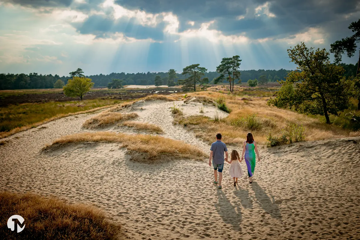 Jong gezin in Drunense Duinen in Brabant tijdens zonsondergang.