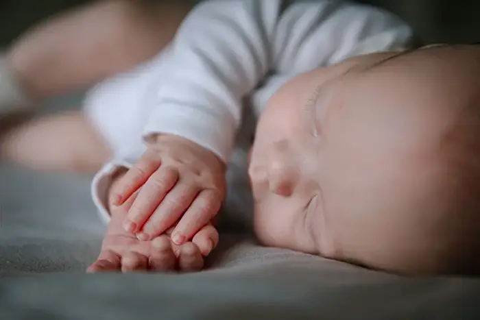 Gezin met baby en klein kind tijdens een newborn fotoshoot met pure connectie tussen baby en kind thuis