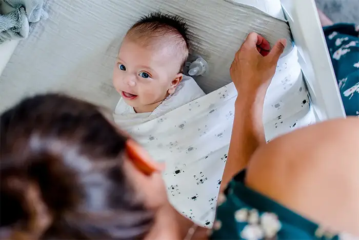 Newbornshoot thuis met baby in bedje en ouders in Noord-Brabant
